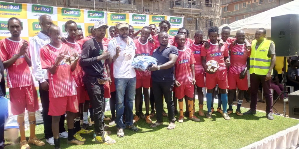 CEO-Betika-Nicholas-Mruttu-at-the-centre-presents-Kits-to-one-of-the-teams