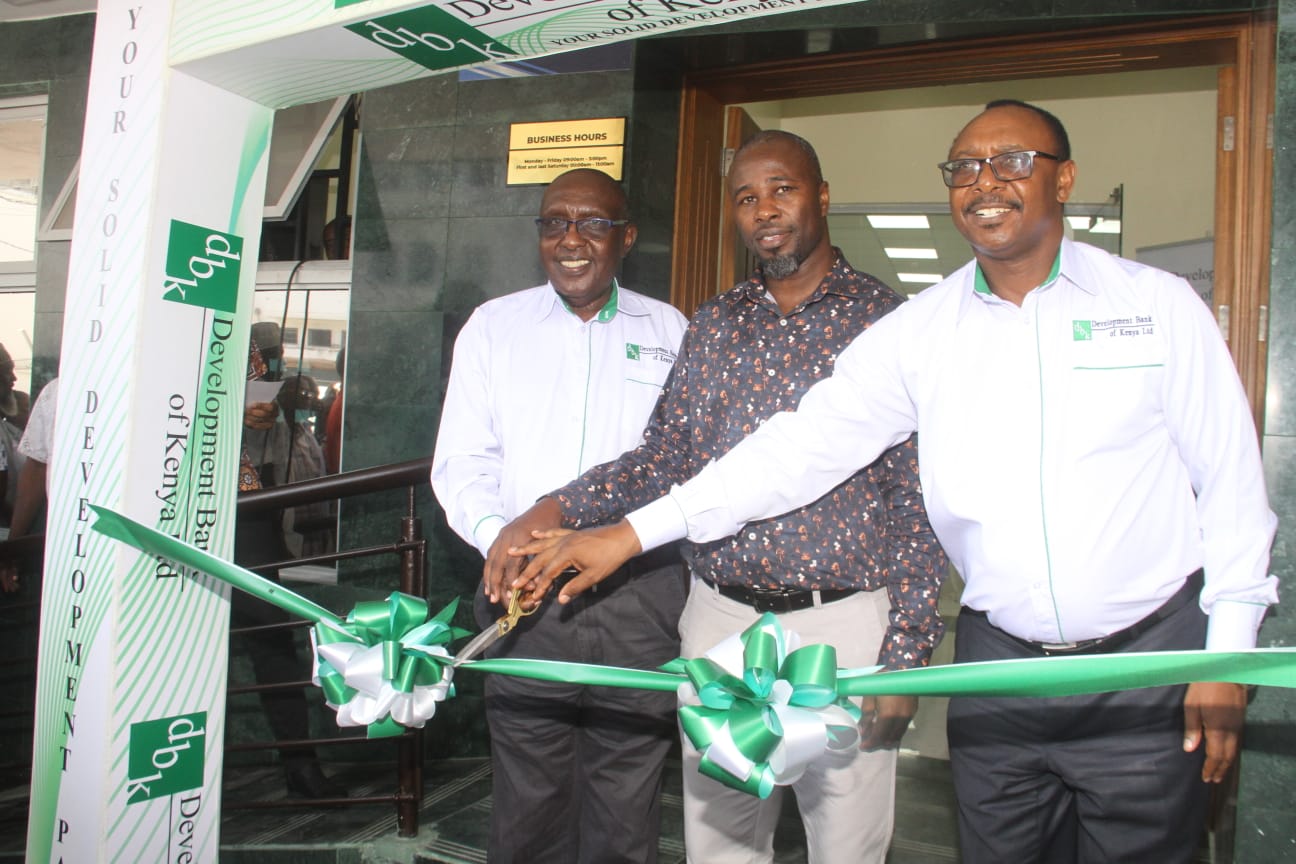 Development Bank of Kenya Chairman Ndungu Githinji (left) and the bank’s Chief Executive Officer and Managing Director Johnson Kiniti (right) are joined by Mombasa County government County Executive Committee Member for Finance and Economics Evans Owanda in cutting ribbon tape to officially open their new branch in Moi avenue , Mombasa on Thursday